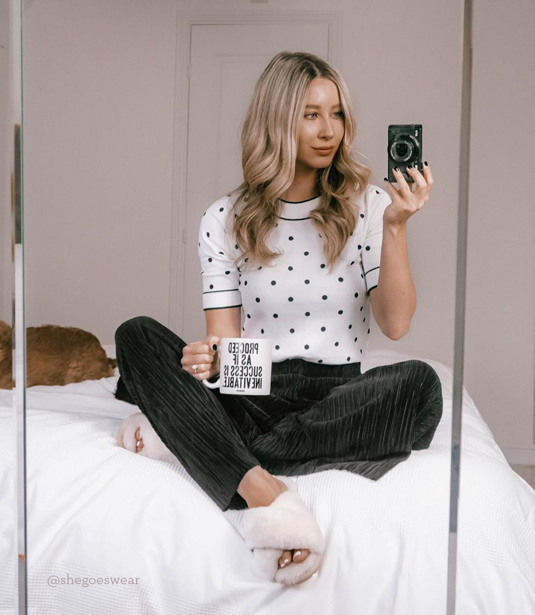 Influencer sitting on bed taking photo of EMU Mayberry sheepskin slippers