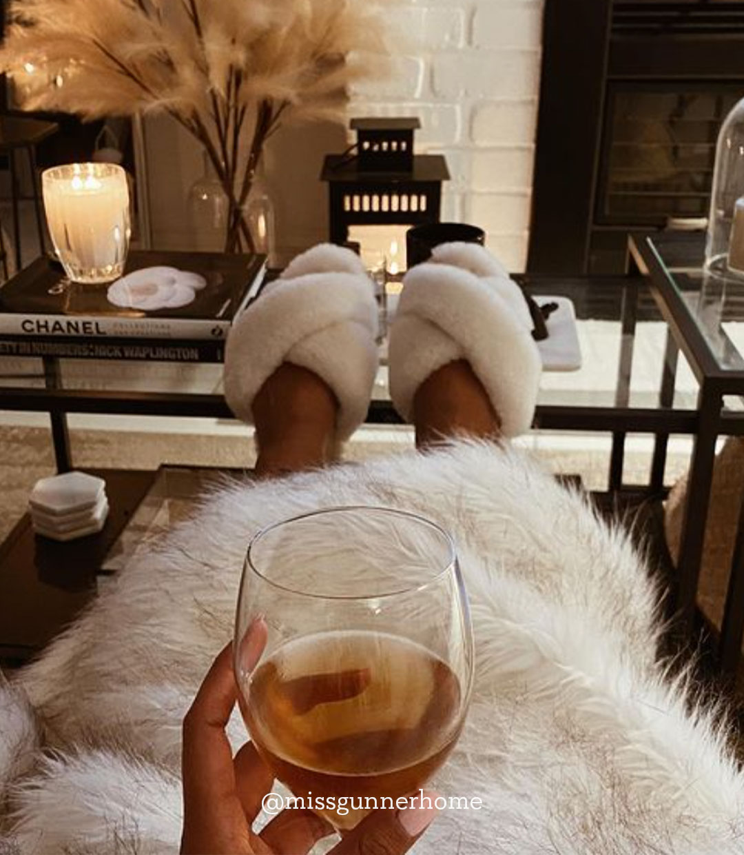 Woman sitting on couch with glass of wine wearing EMU Mayberry slippers