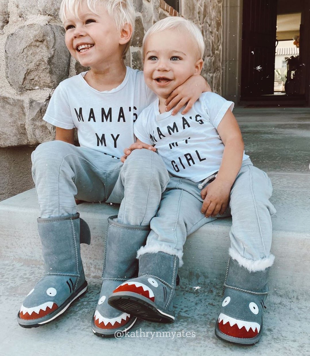 Young boy and girl sitting on step smiling and wearing EMU Little Creature Shark boots