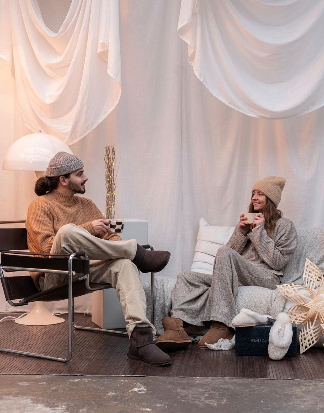 Couple wearing matching Australian sheepskin boots in trendy industrial studio warehouse