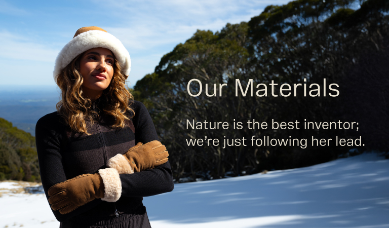 Model standing in snow with sheepskin gloves and sheepskin hat. Our Materials. Nature is the best inventor; we're just following her lead.