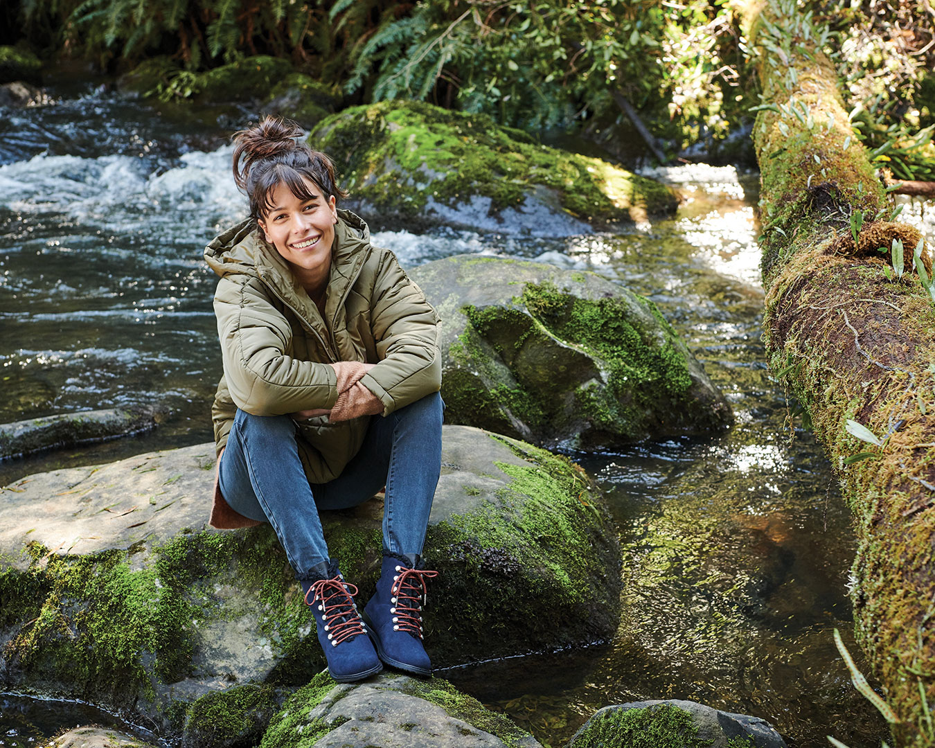 Model sitting on top of rock in Australian native park waterway wearing EMU waterproof hiking boot