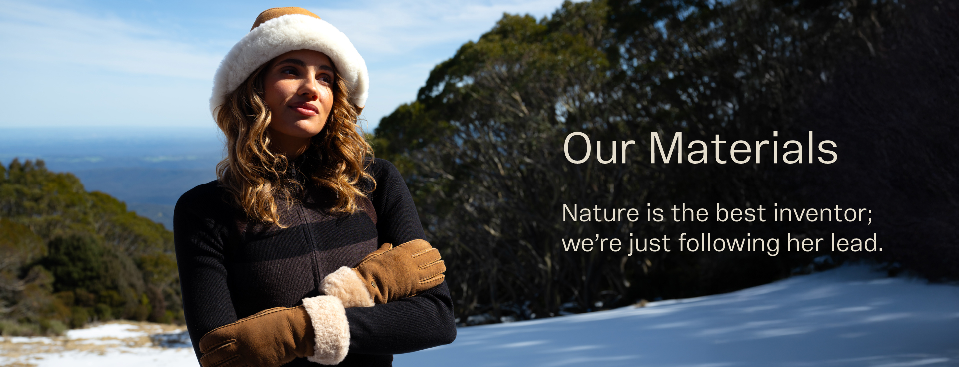Model standing in snow with sheepskin gloves and sheepskin hat. Our Materials. Nature is the best inventor; we're just following her lead.