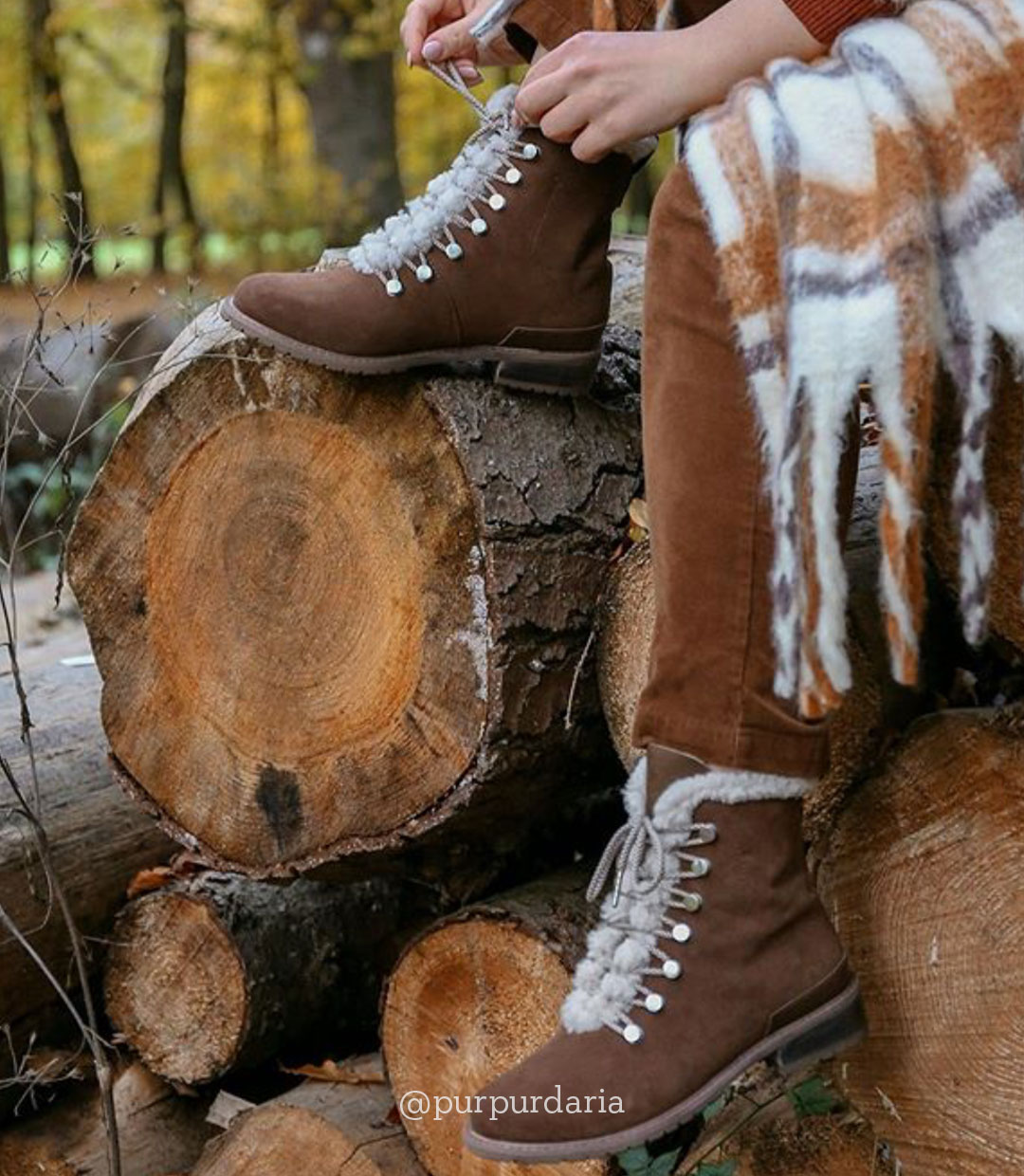 Woman wearing Billington hiking-style boot sitting on log outdoors